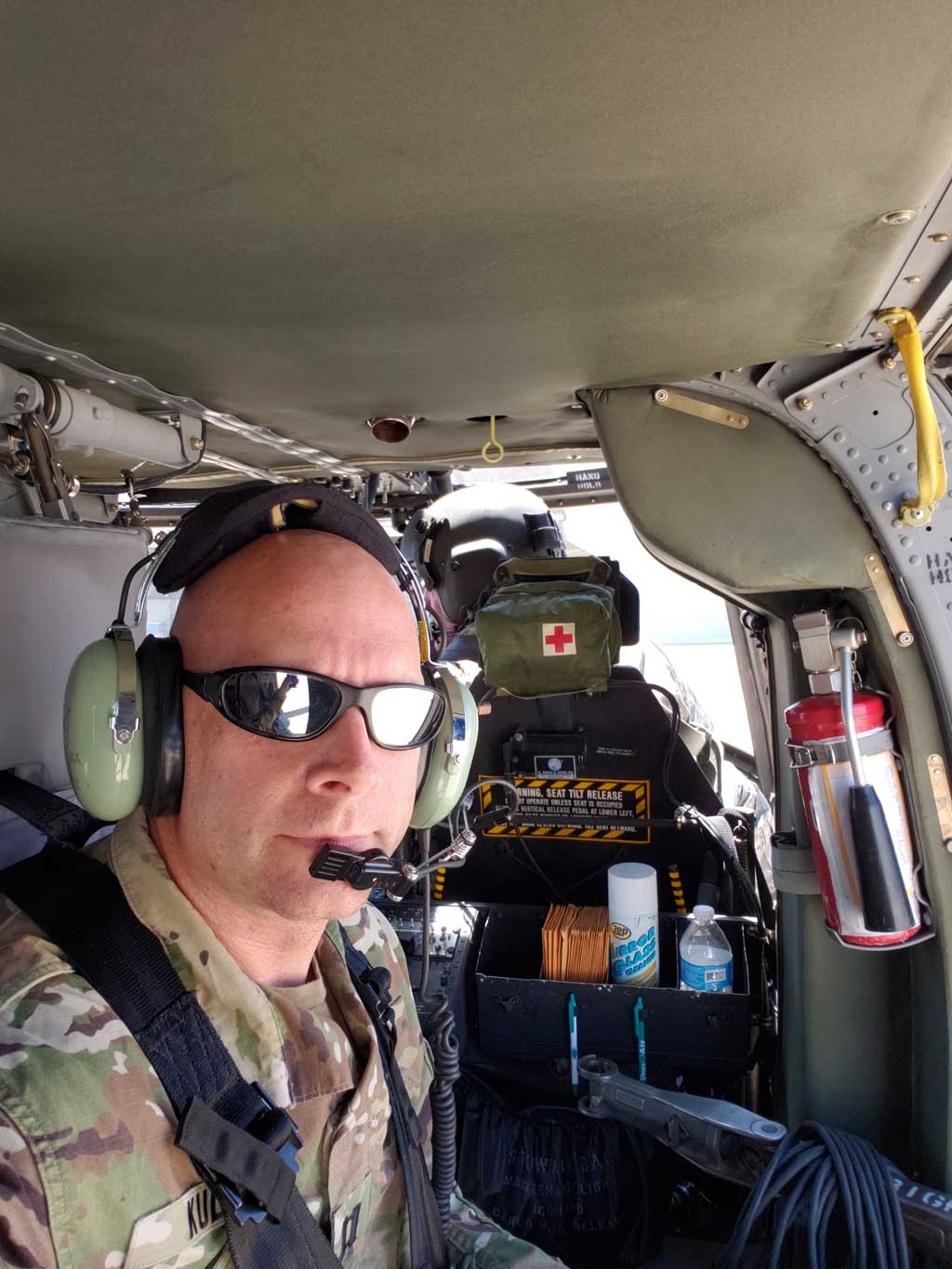 Dr. Johnny Kula in military gear, inside a helicopter